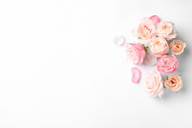 Photo of Beautiful roses and space for text on white background, top view