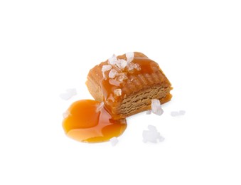 Photo of Yummy caramel candy and sea salt isolated on white