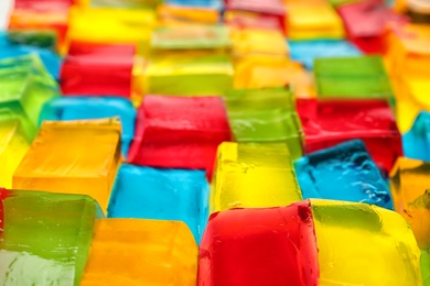 Photo of Tasty colorful jelly cubes as background, closeup