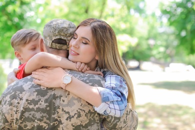 Photo of Male soldier with his family outdoors. Military service