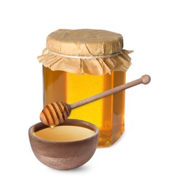 Image of Natural honey dripping from dipper into wooden bowl. Jar full of honey on white background