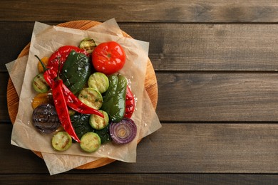 Photo of Delicious grilled vegetables on wooden table, top view. Space for text