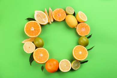 Photo of Flat lay composition with tangerines and different citrus fruits on green background. Space for text