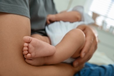 Photo of Father holding his sleeping baby on blurred background, closeup