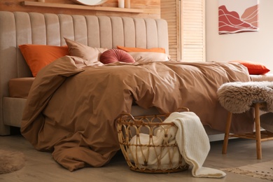 Photo of Bed with brown linens in cozy bedroom. Interior design