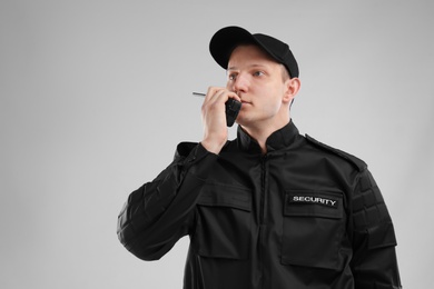 Photo of Male security guard using portable radio transmitter on color background