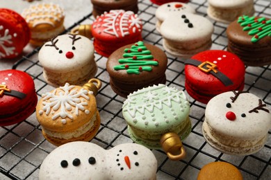 Photo of Beautifully decorated Christmas macarons on light grey table, closeup