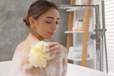 Photo of Woman taking bath with shower gel in bathroom