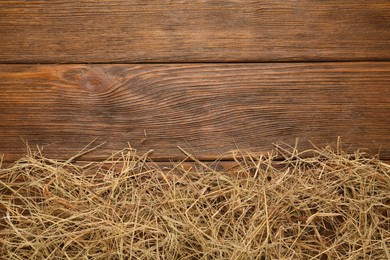 Photo of Dried hay on wooden background, flat lay. Space for text