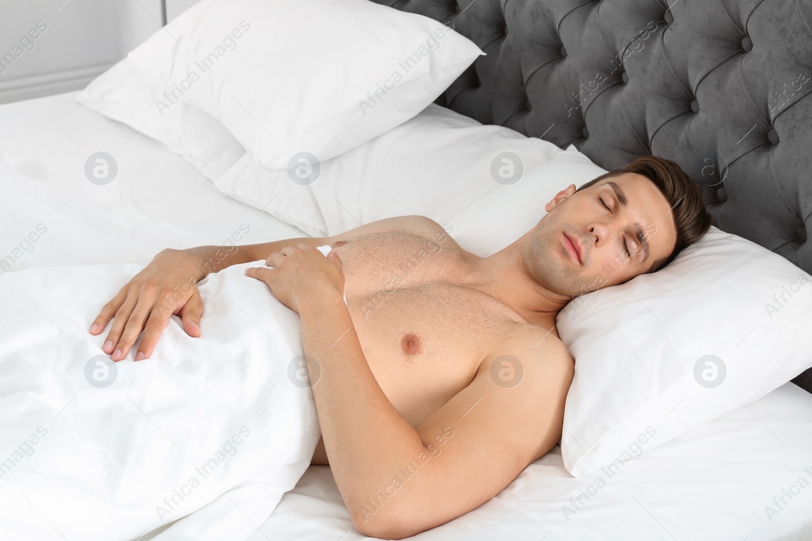 Young man sleeping in bed at home Photo of Young man sleeping in bed at home