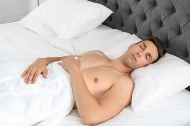 Photo of Young man sleeping in bed at home