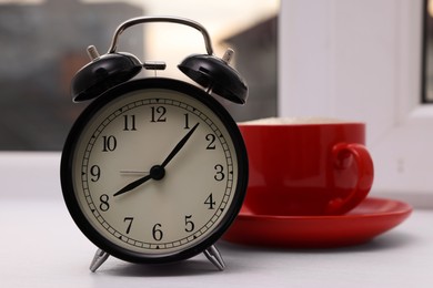 Photo of Alarm clock near window indoors, space for text. Morning time