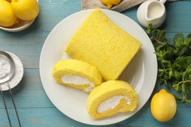 Photo of Delicious cake roll, lemons, mint and powdered sugar on light blue wooden table, flat lay