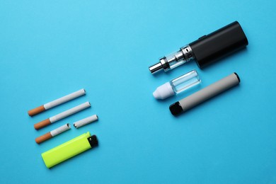 Photo of Lighter, liquid solution, electronic and regular cigarettes on light blue background, flat lay
