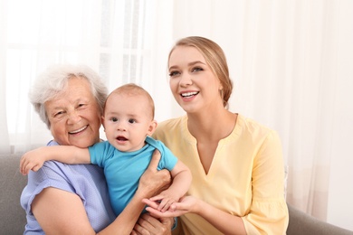Photo of Happy young woman with her child and grandmother at home