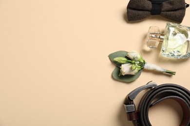 Photo of Wedding stuff. Flat lay composition with stylish boutonniere on beige background, space for text