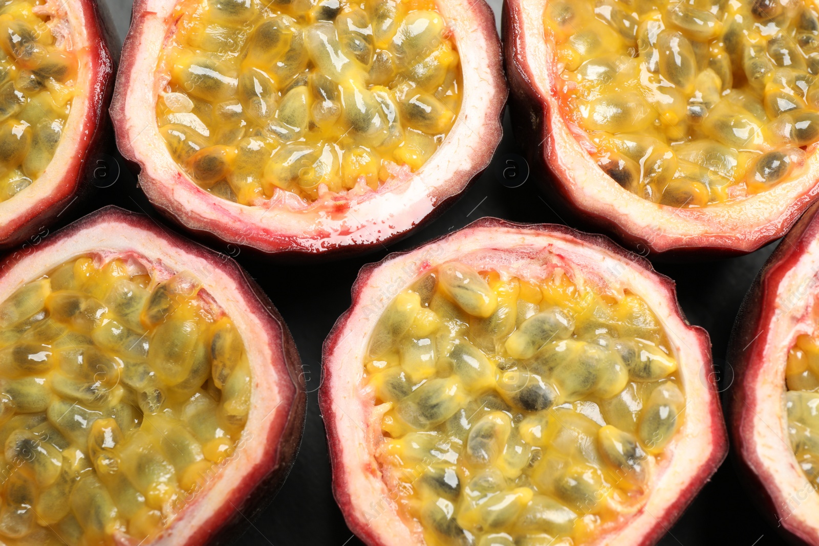 Photo of Halves of passion fruits (maracuyas) on table, flat lay