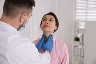 Photo of Doctor examining thyroid gland of patient in hospital