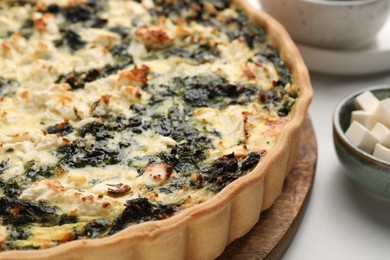 Photo of Delicious homemade spinach quiche on table, closeup