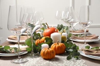 Photo of Beautiful autumn table setting. Plates, cutlery, glasses, pumpkins and floral decor