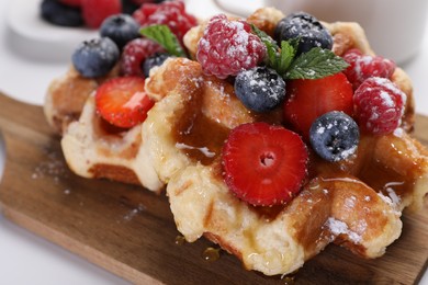 Photo of Delicious Belgian waffles with fresh berries served on table, closeup