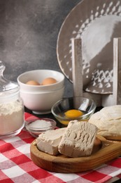 Photo of Compressed yeast, salt, flour, eggs and dough on wooden table