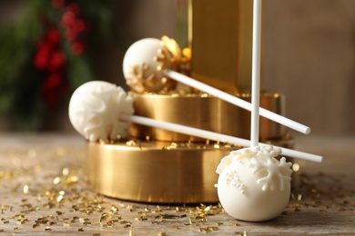 Delicious Christmas ball cake pops on wooden table, closeup