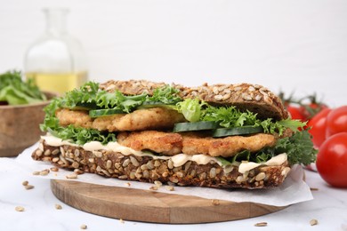Photo of Delicious sandwich with schnitzel on white table