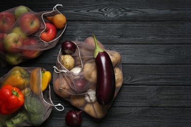Photo of Different fresh vegetables in bags on black wooden table, flat lay and space for text. Farmer harvesting