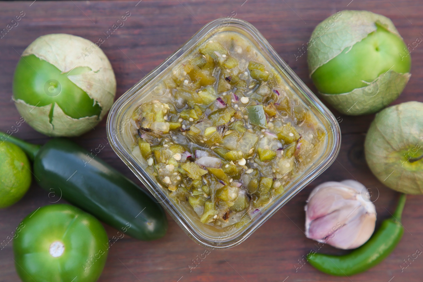 Photo of Tasty salsa sauce and ingredients on wooden table, flat lay