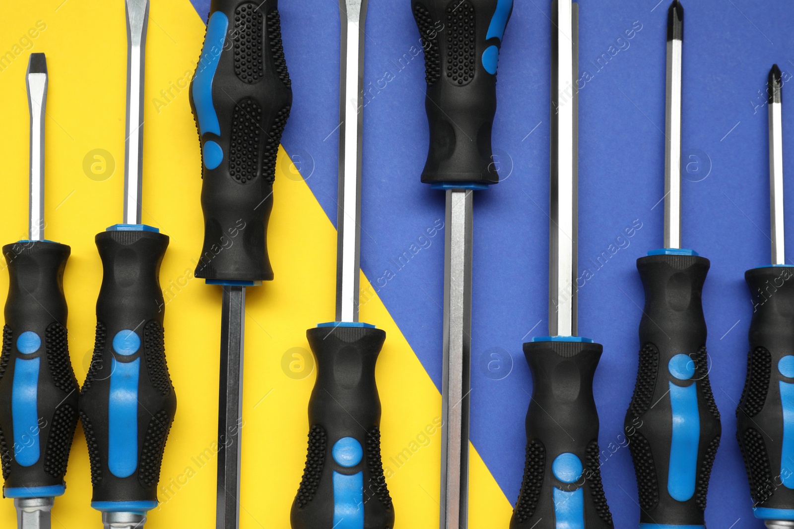 Photo of Set of screwdrivers on color background, flat lay