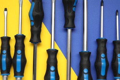 Set of screwdrivers on color background, flat lay