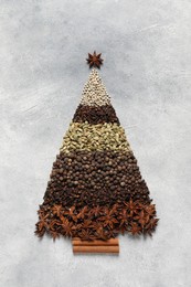 Photo of Christmas tree made of different spices on gray textured table, top view