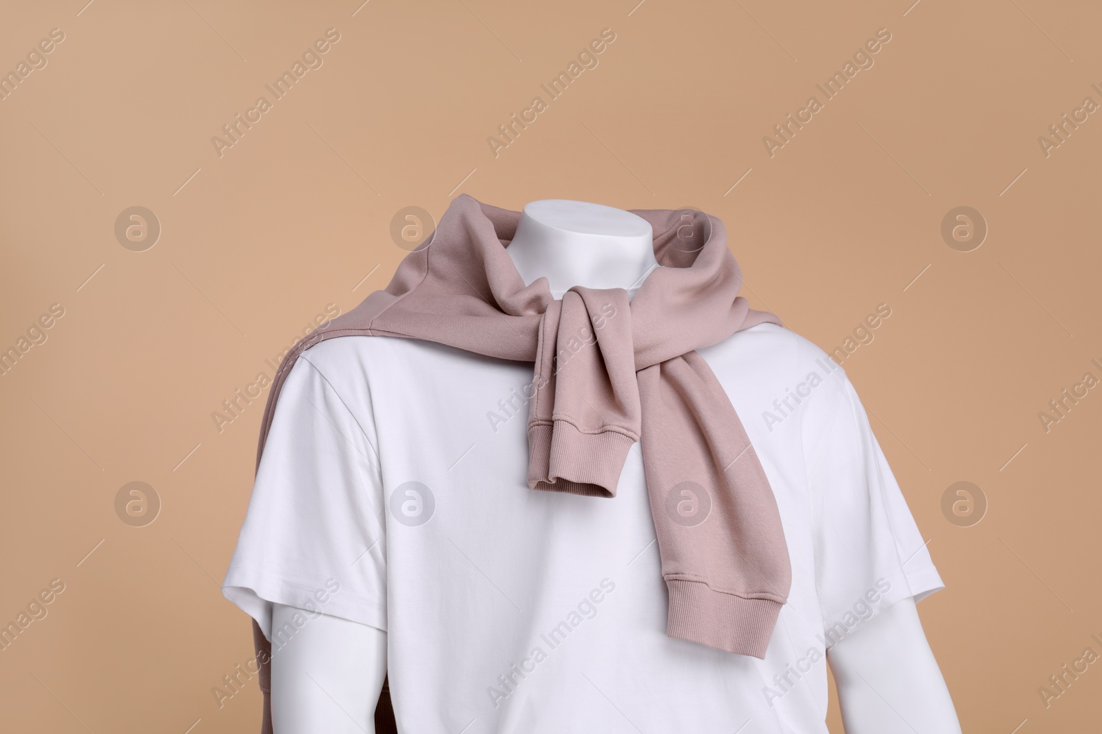 Photo of Male mannequin dressed in white t-shirt and sweater on beige background