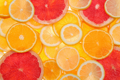 Photo of Slices of fresh tangerines and different citrus fruits on white background, top view