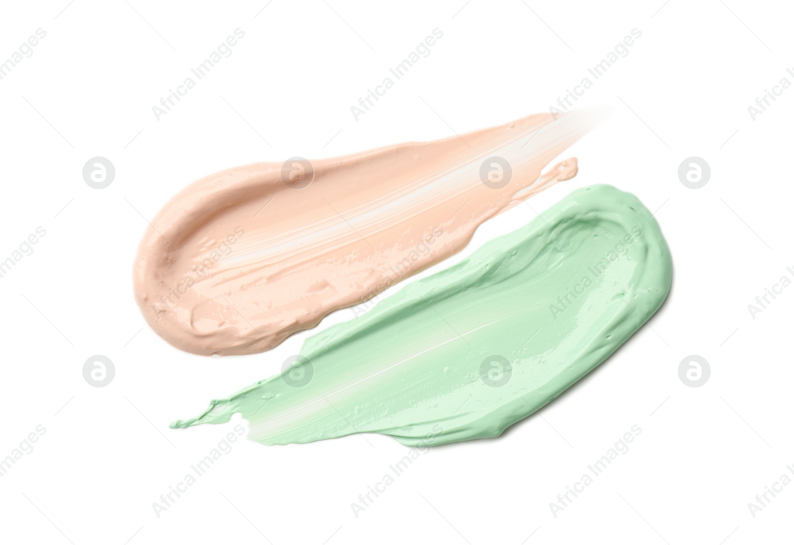 Photo of Strokes of pink and green color correcting concealers isolated on white, top view