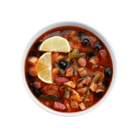 Photo of Meat solyanka soup with sausages, olives and vegetables in bowl isolated on white, top view