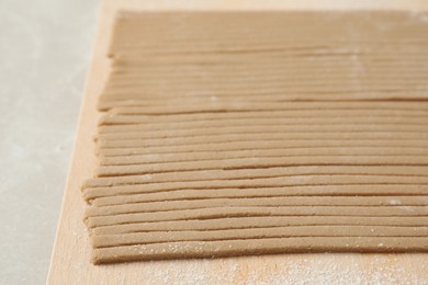 Photo of Uncooked soba (buckwheat noodles) on wooden table, closeup