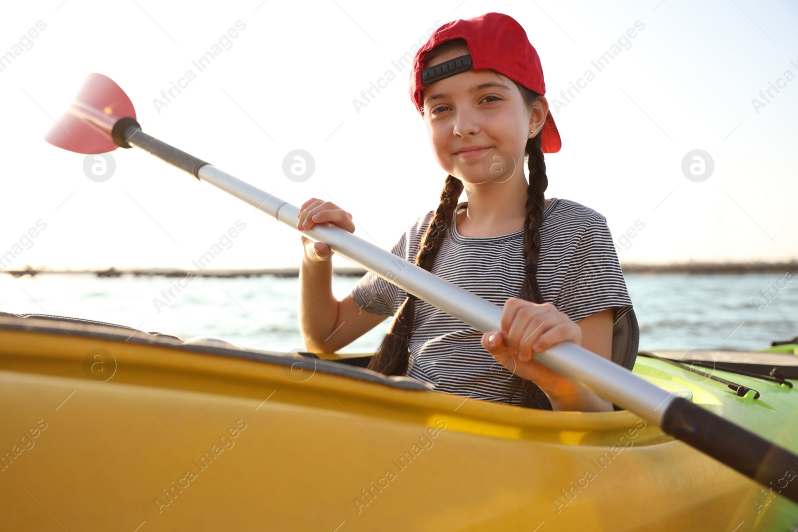 Photo of Happy little girl kayaking on river. Summer camp activity