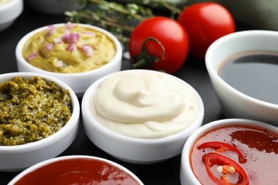 Photo of Different tasty sauces in bowls on table, closeup