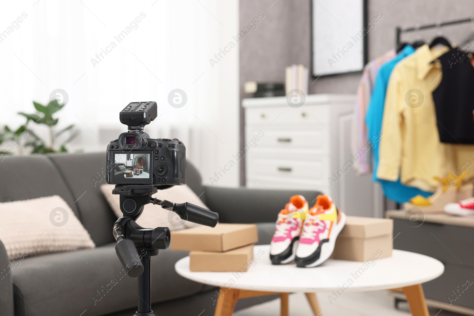 Photo of Fashion blogger's workplace. Shoes and clothes indoors, focus on camera