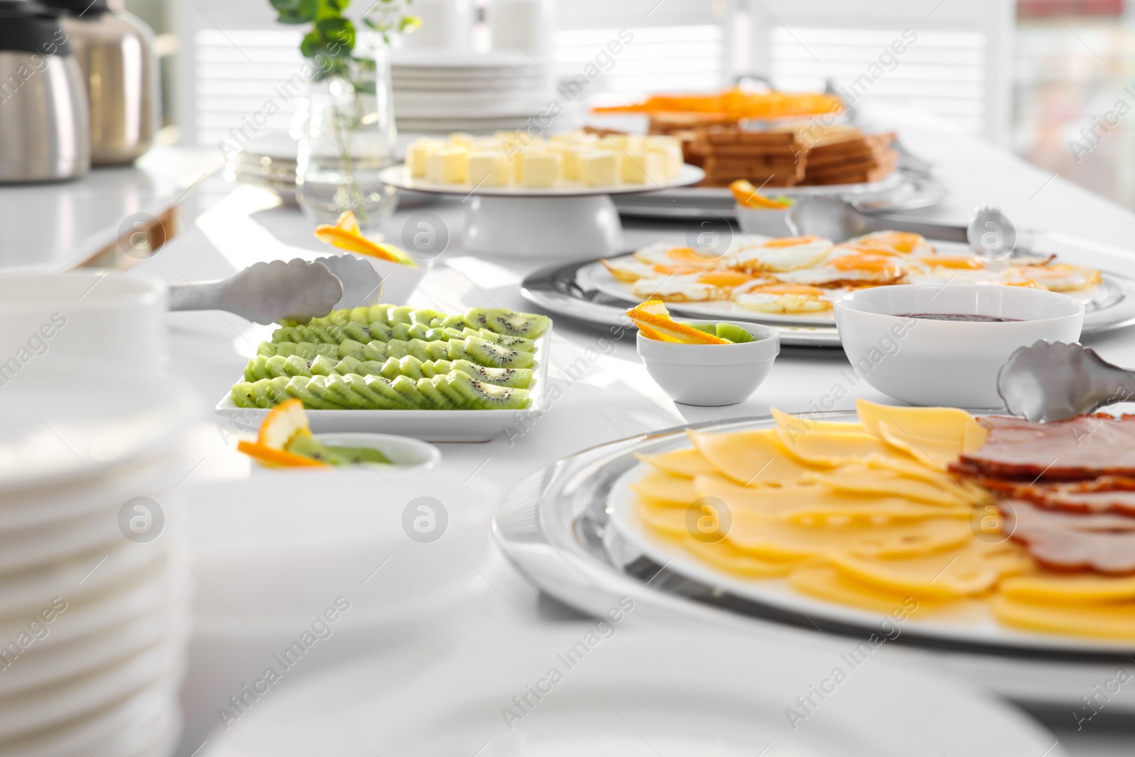 Photo of Clean dishware and different meals for breakfast on white table indoors. Buffet service