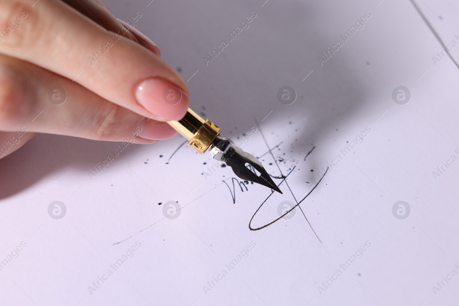 Photo of Woman signing on sheet of paper with fountain pen, closeup