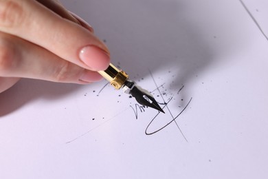 Woman signing on sheet of paper with fountain pen, closeup