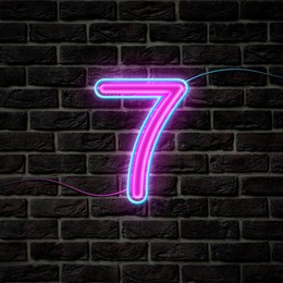 Image of Glowing neon number 7 sign on brick wall