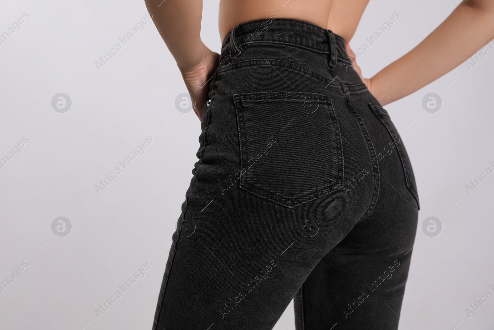 Photo of Woman in stylish black jeans on light background, closeup. Space for text