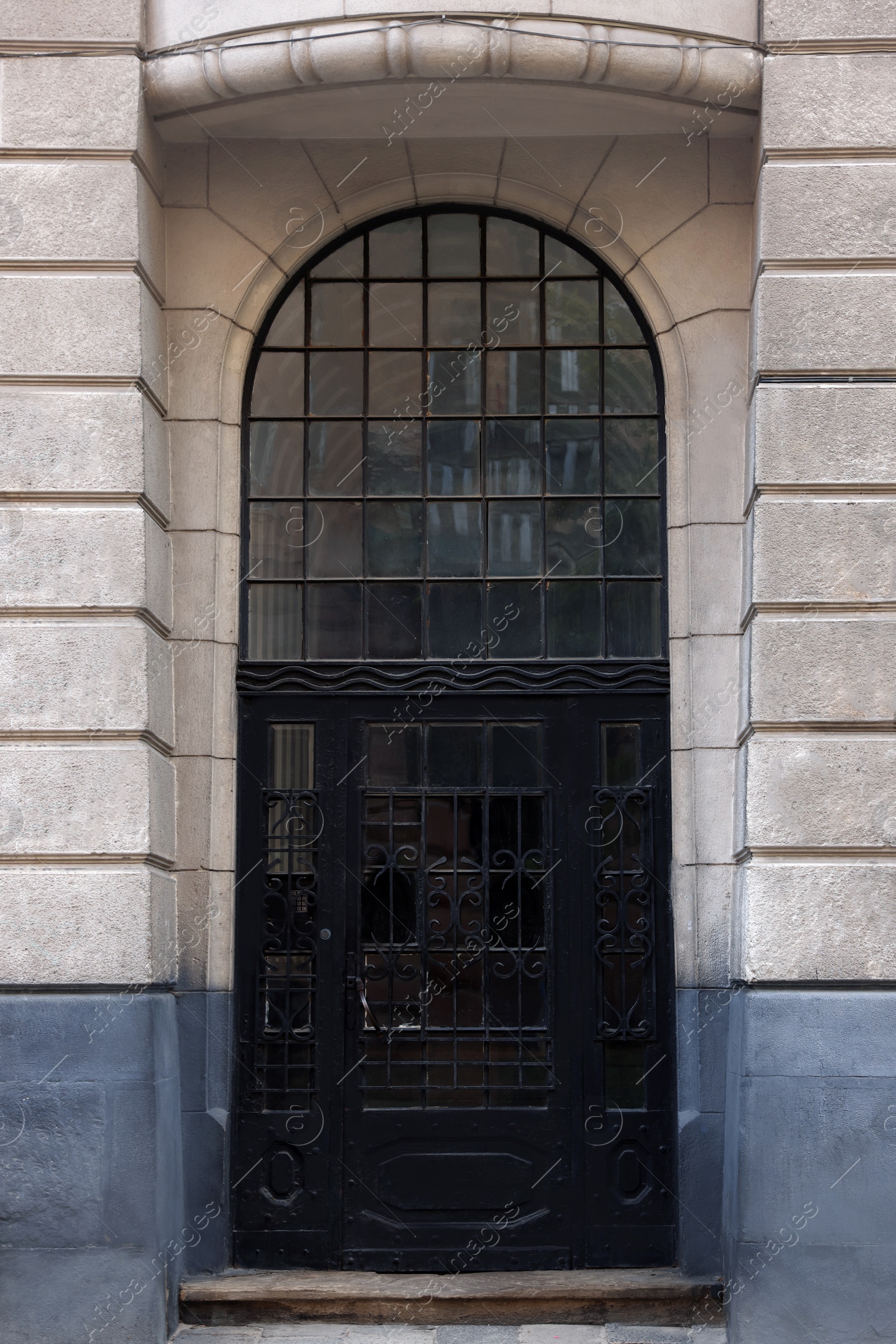 Photo of Entrance of house with beautiful arched door and transom window