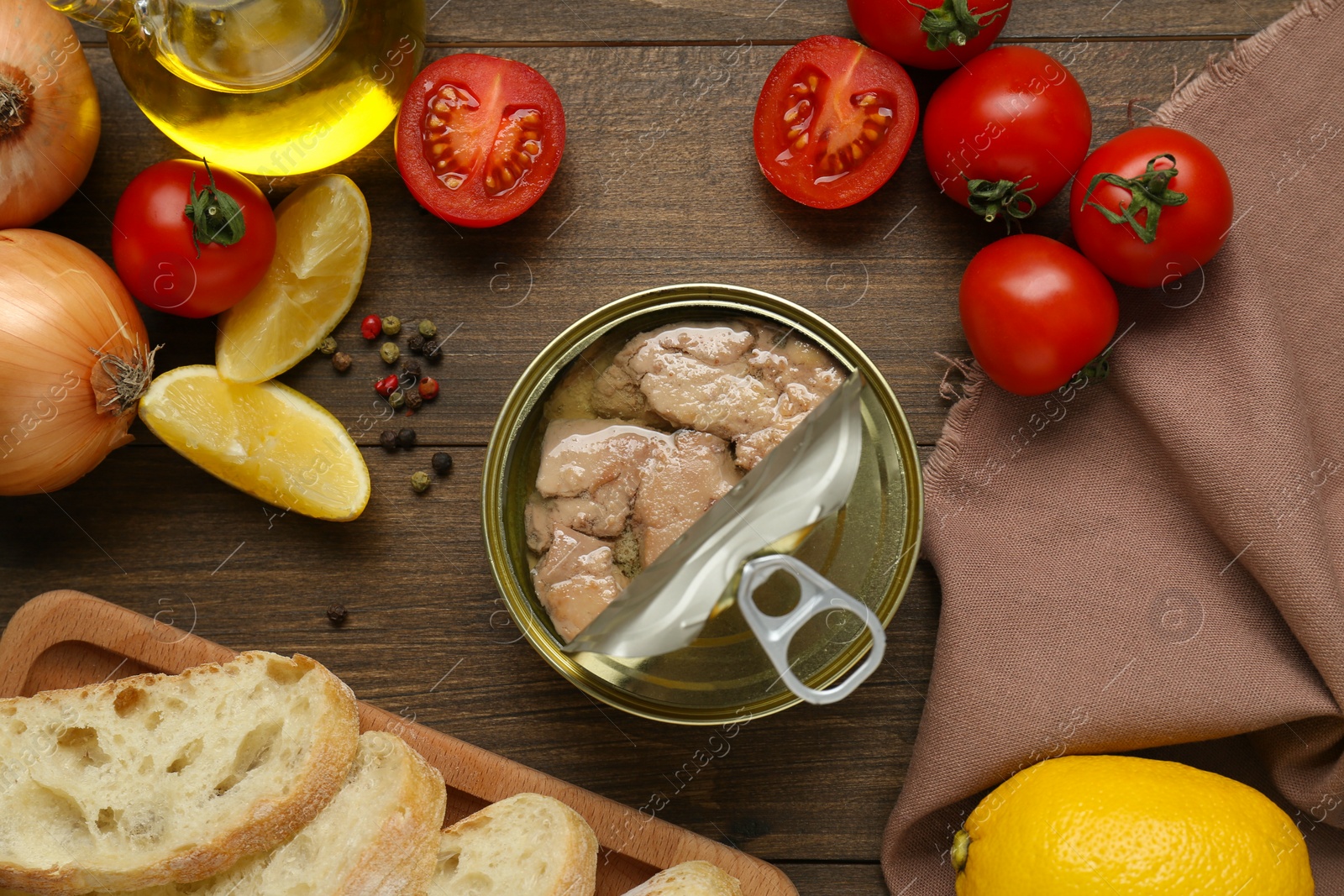 Photo of Flat lay composition with tin can of tasty cod liver and different products on wooden table