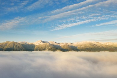 Image of Aerial view of beautiful mountains above clouds