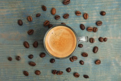 Photo of Cup of tasty coffee on blue wooden table, flat lay